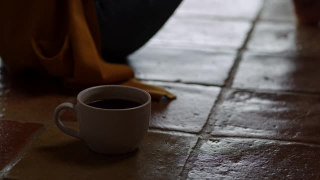 一名年轻女子一边喝着咖啡，一边在手机上发短信视频素材