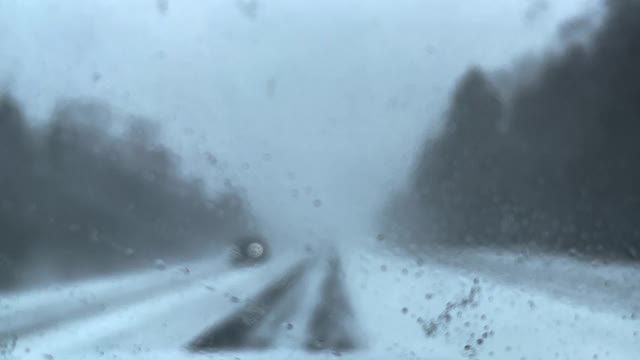 看着窗外，在冬天的雪地上开车。视频素材