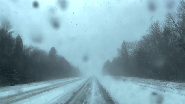 看着窗外，在冬天的雪地上开车。视频素材