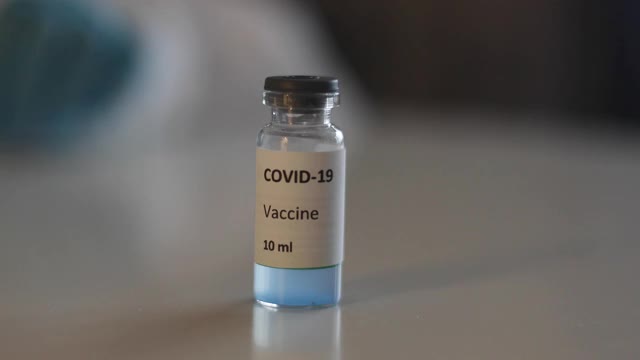 Covid - 19疫苗接种概念、研制和创造，实验室医生或科学家持有单剂新型冠状病毒疫苗，注射器和安瓿与SARS-CoV-2疫苗接种视频素材