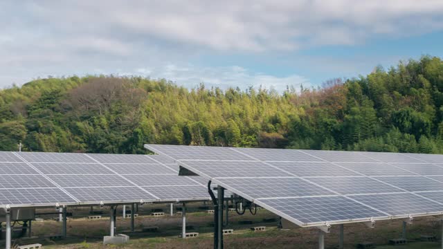 4K延时大型工业太阳能农场生产集中太阳能发电清洁电力对山和云的背景，绿色能源的概念。视频素材