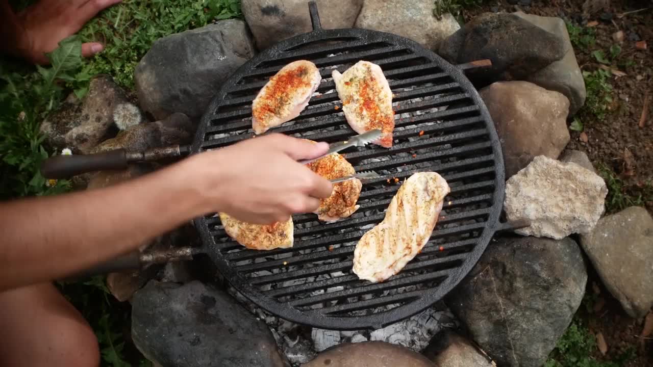 在院子里的烤架上烤着肉和香肠，烤鸡和香肠视频素材