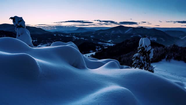 蓝色的日出早晨在野生的冬季山脉自然与冰冻雪林景观视频素材