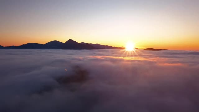 鸟瞰图的金色日落以上的云彩在傍晚的山区自然景观视频素材