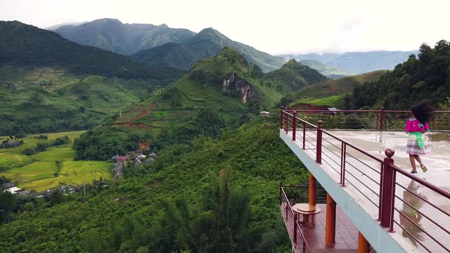 鸟瞰图的女孩在文化服装上奔跑与风景自然的屋顶视频素材