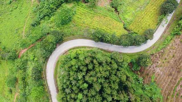 鸟瞰图在乡村蜿蜒的道路与移动的车辆。视频素材