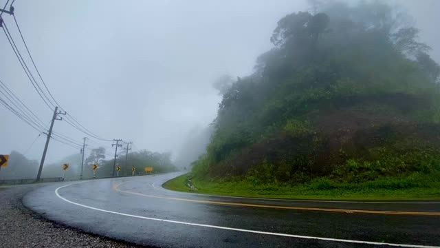 雾在泰国的山上升起。乡村山水，阴雨暴雨天气。曲线线道路阴天，视频素材