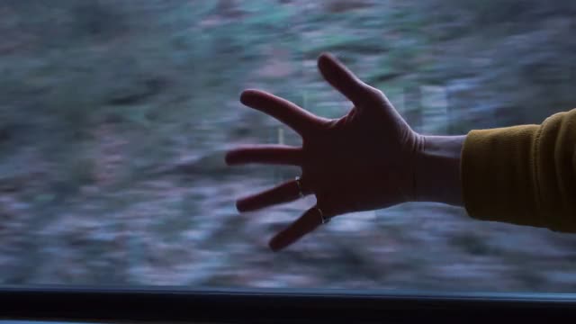 Hand on the background of the road movement in train carriage on the journey的翻译是:手在旅途的火车车厢的道路运动的背景。视频素材