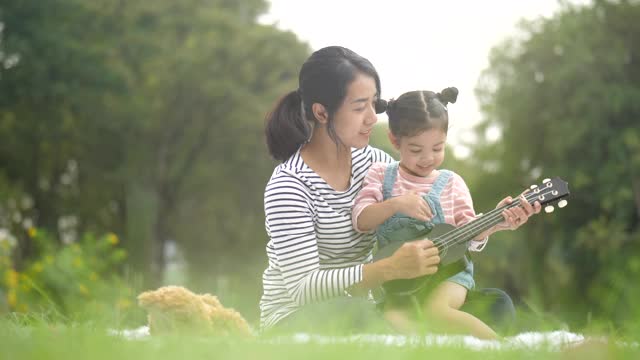 妈妈教女孩演奏音乐的节奏视频素材