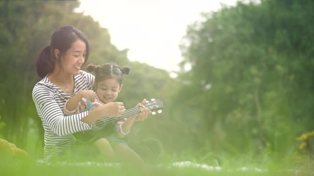 妈妈教女孩演奏音乐的节奏视频素材