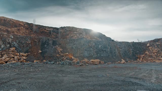 一个摄影师走在高山的高原上，他的相机以岩石为背景视频素材