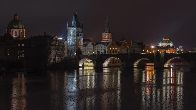 布拉格市中心的伏尔塔瓦河和一座石桥，以及捷克共和国布拉格夜晚街灯和鸭子表面的灯光。视频素材