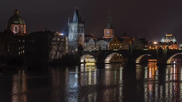 布拉格市中心的伏尔塔瓦河和一座石桥，以及捷克共和国布拉格夜晚街灯和鸭子表面的灯光。视频素材