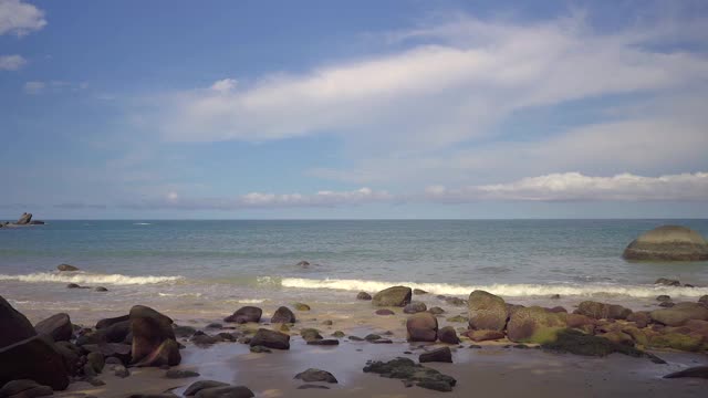 岩石海滩的背景，对微小的云天空视频素材