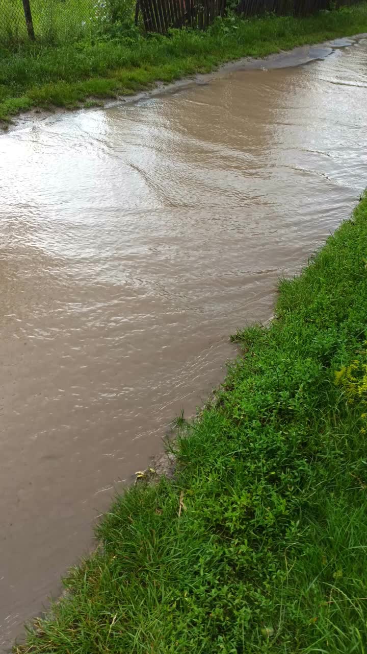 垂直屏幕方向视频。街上水淹，人行道上有大水坑，雨天，暴风雨天气。视频素材