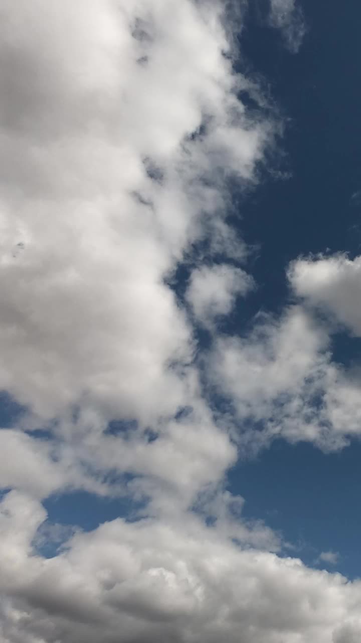 夏日蔚蓝的天空中漂浮着大量的积云。间隔拍摄。多云的天空作为背景。垂直视频。视频素材