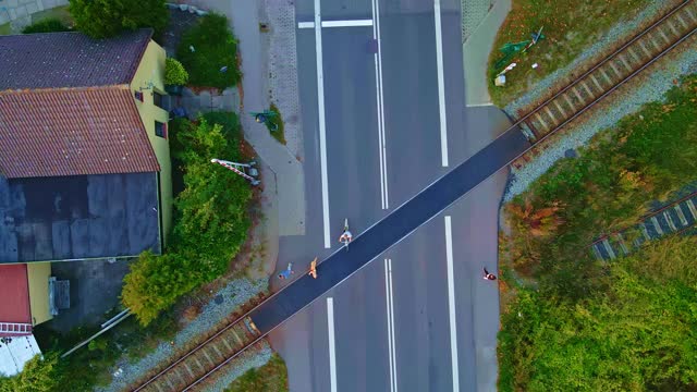 铁路穿过有行人和汽车经过的道路。自上而下鸟瞰图。视频素材