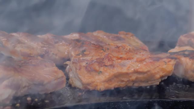 慢镜头:厨师用火钳在火盆上烤牛排视频素材