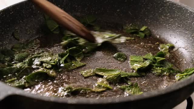 在煎锅中搅拌鼠尾草和黄油视频素材