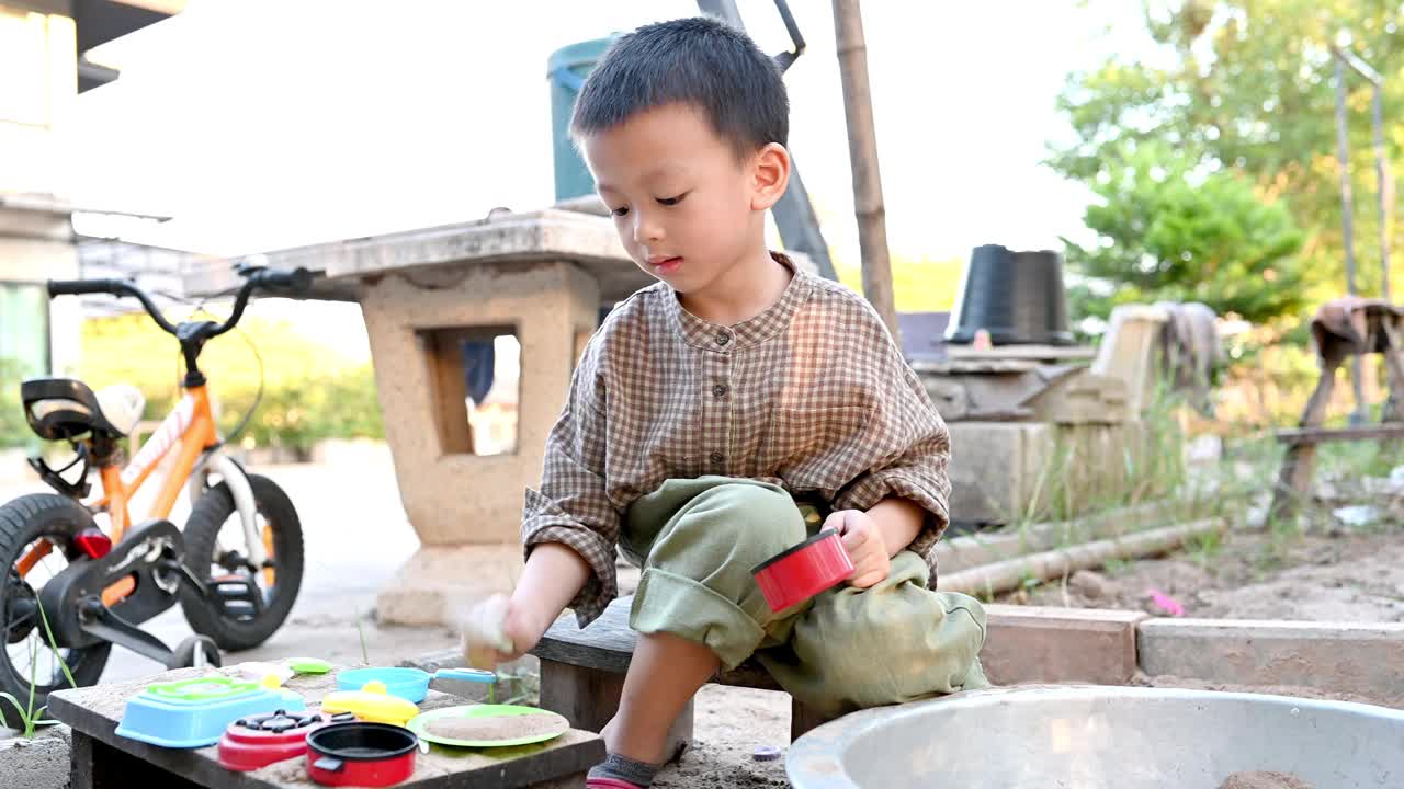 亚洲男孩正在用玩具在沙盒里玩沙视频下载