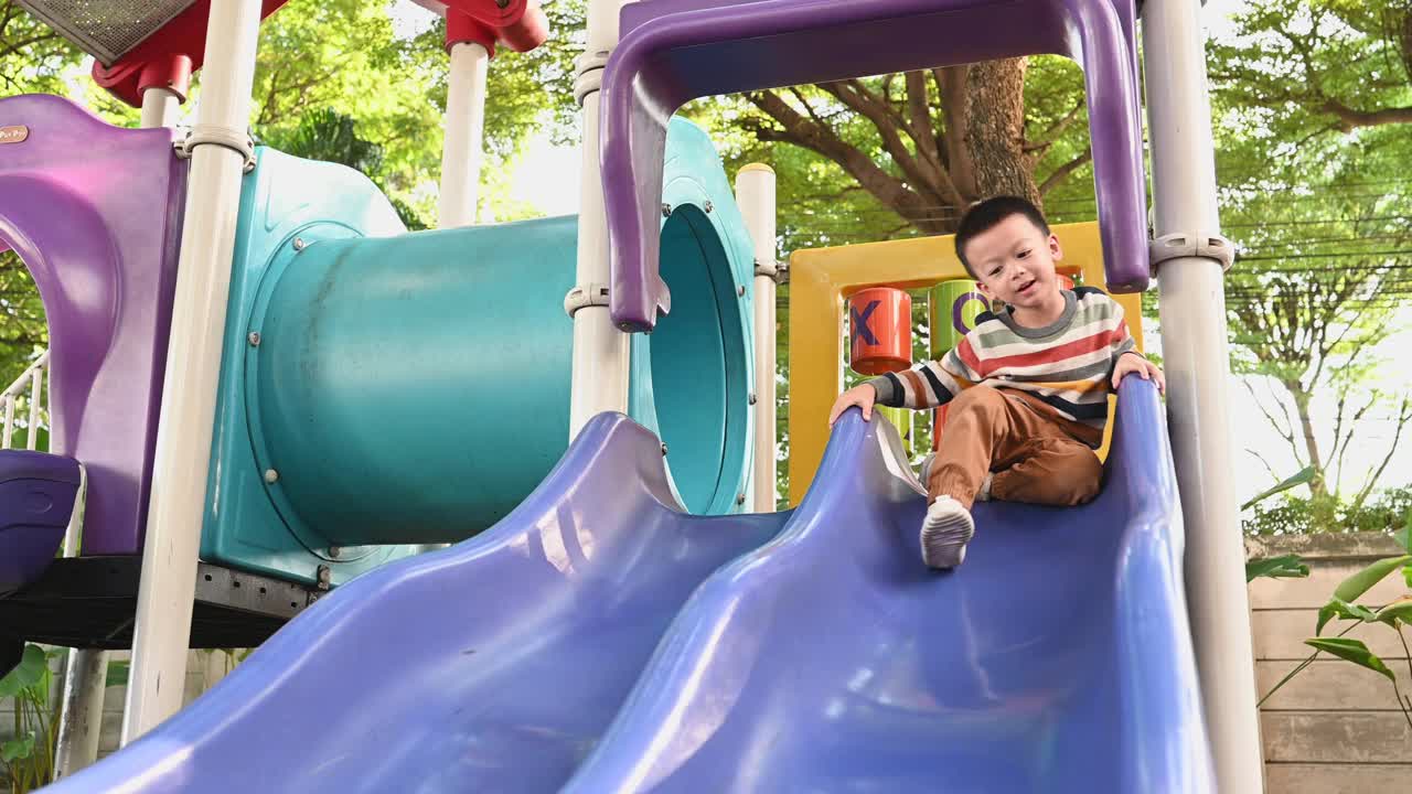 可爱的亚洲男孩在操场上玩得很开心视频下载