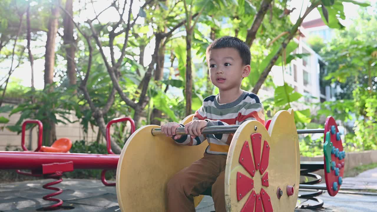 可爱的亚洲男孩在操场上玩得很开心视频下载