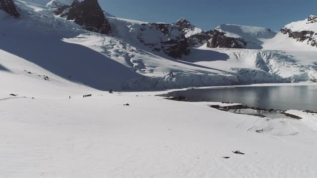 无人机拍摄通过雪斯瓦尔巴特群岛，斯匹次卑尔根群岛，北极，北极圈的徒步旅行路线视频下载