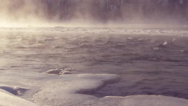 在寒冷的冬天，雾气被冰雪覆盖的河流视频素材