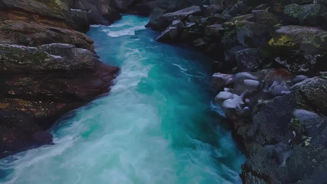 冰冷的冰川水流过冰冻的悬崖，顺着河流而下。4 k的视频视频素材