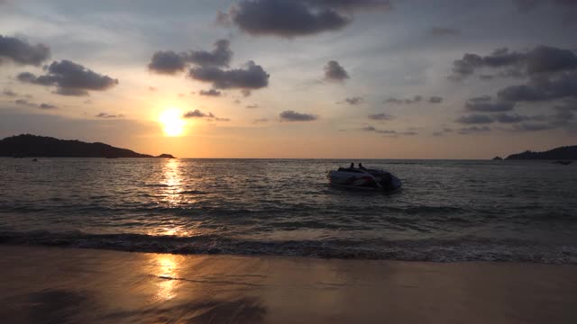 普吉岛海滩上的日落风景。一艘船在海上航行。视频素材