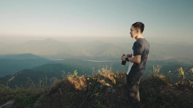 摄影师在泰国清莱省著名的旅游景点Doi Pha Tang拍摄山景视频素材