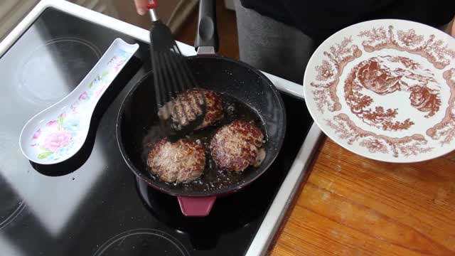 厨师把肉片从锅里放到盘子里。自制的食物。烹饪。多汁的肉视频素材