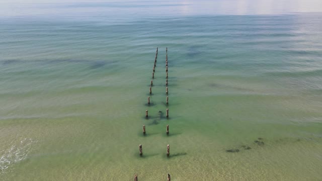 美丽的老木码头在晴朗的一天，蓝天在地中海海岸的海滩，鸟瞰图视频下载