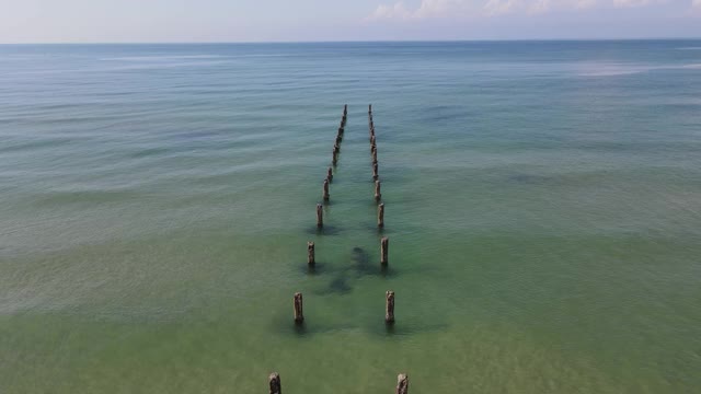 美丽的老木码头在晴朗的一天，蓝天在地中海海岸的海滩，鸟瞰图视频下载