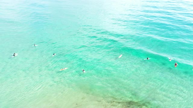 从无人机角度拍摄的黄金海岸清澈海水上的4k视频，人们在冲浪视频素材