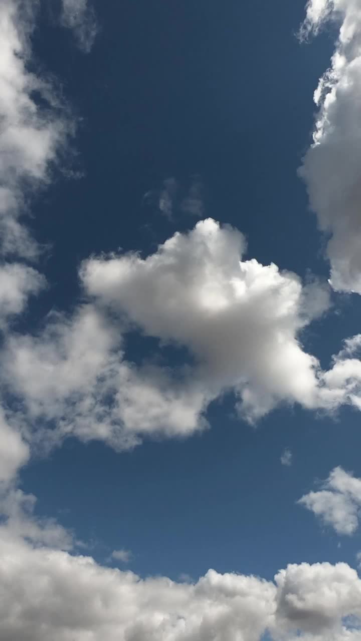 夏日蔚蓝的天空中漂浮着大量的积云。间隔拍摄。多云的天空作为背景。垂直视频。视频素材