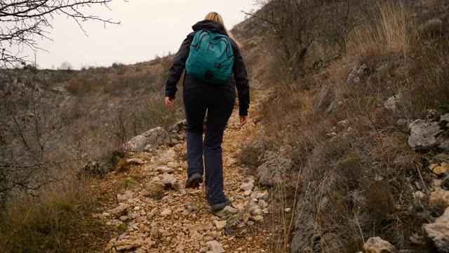 成熟的女人在山间徒步旅行视频素材