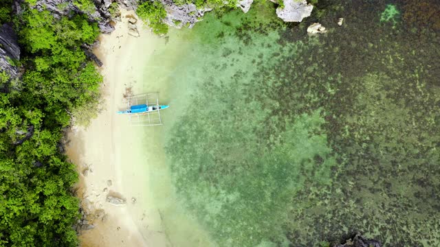 位于环礁和绿松石环礁上的热带岛屿。岩石岛与白色沙滩，鸟瞰图视频素材