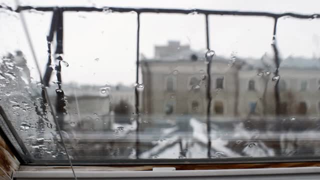 在肮脏的春日，雨点落在窗玻璃上视频素材