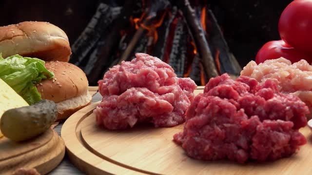 鸡肉，牛肉和猪肉生碎肉在篝火的背景下视频素材