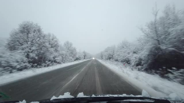 汽车观点。2019冠状病毒病(COVID-19)大流行期间，在大雪中行驶在高速公路上上班。生活忙碌，交通慢了下来。视频素材