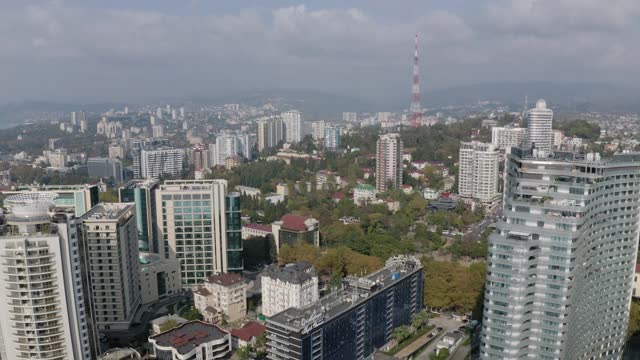 空中平移视图旋转拍摄索契城市景观与地区街道基础设施和海岸海滨。从上面拍摄的令人惊叹的山水旅游城市度假胜地全景视频素材