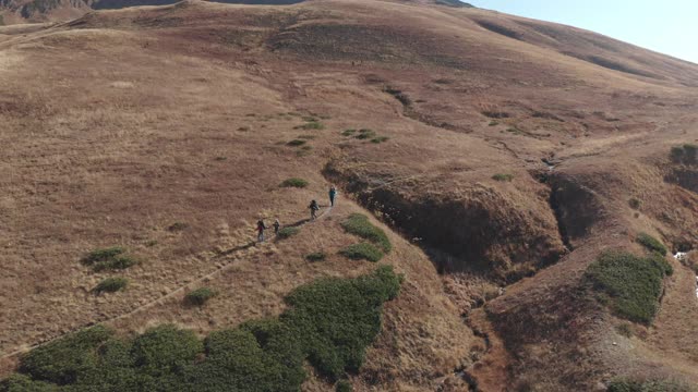 鸟瞰飞行组团的背包客徒步旅行，在自然山地景观享受冒险。积极的人进行徒步旅行，花时间户外露营极端的生活方式视频素材