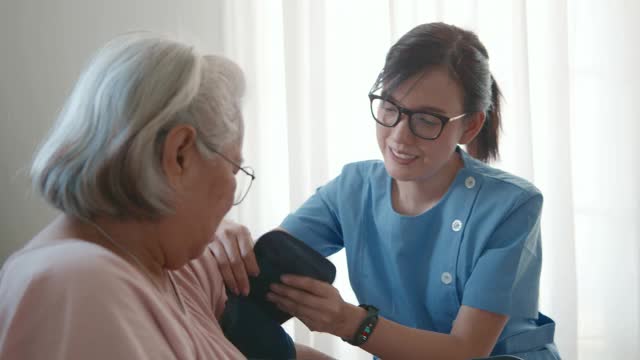 女医生为一位老年病人检查血压。视频素材