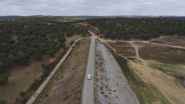 露营车房车无人机鸟瞰图通过大坝道路与湖泊水库在Divor大坝在阿连特霍，葡萄牙视频素材