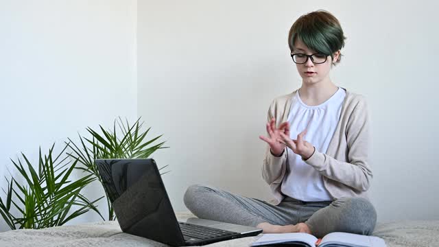 远程学习在线教育。十几岁的女学生使用笔记本电脑在家学习视频素材