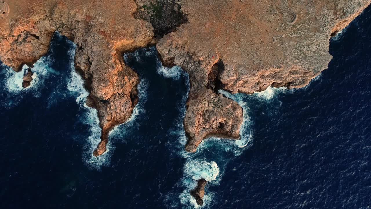 梅诺卡礁和海岸在地中海鸟瞰图。我们可以看到海浪在礁石上翻滚，产生4K的泡沫视频素材