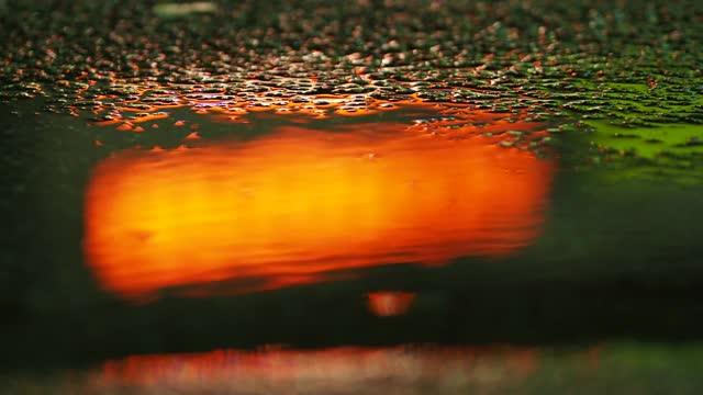 雨后人行道上的水坑里五颜六色的倒影视频素材