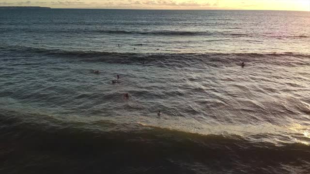 日落时在海浪上冲浪，鸟瞰图视频素材