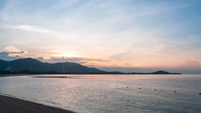 时间流逝的日出在海上，金色的阳光照耀和放松在水面上，美丽的卷积云扩散在蓝天空间。镜头自然天空和海景背景视频素材